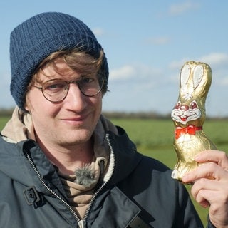 neuneinhalb-Reporter Robert hält einen Schoko-Osterhasen in die Kamera.